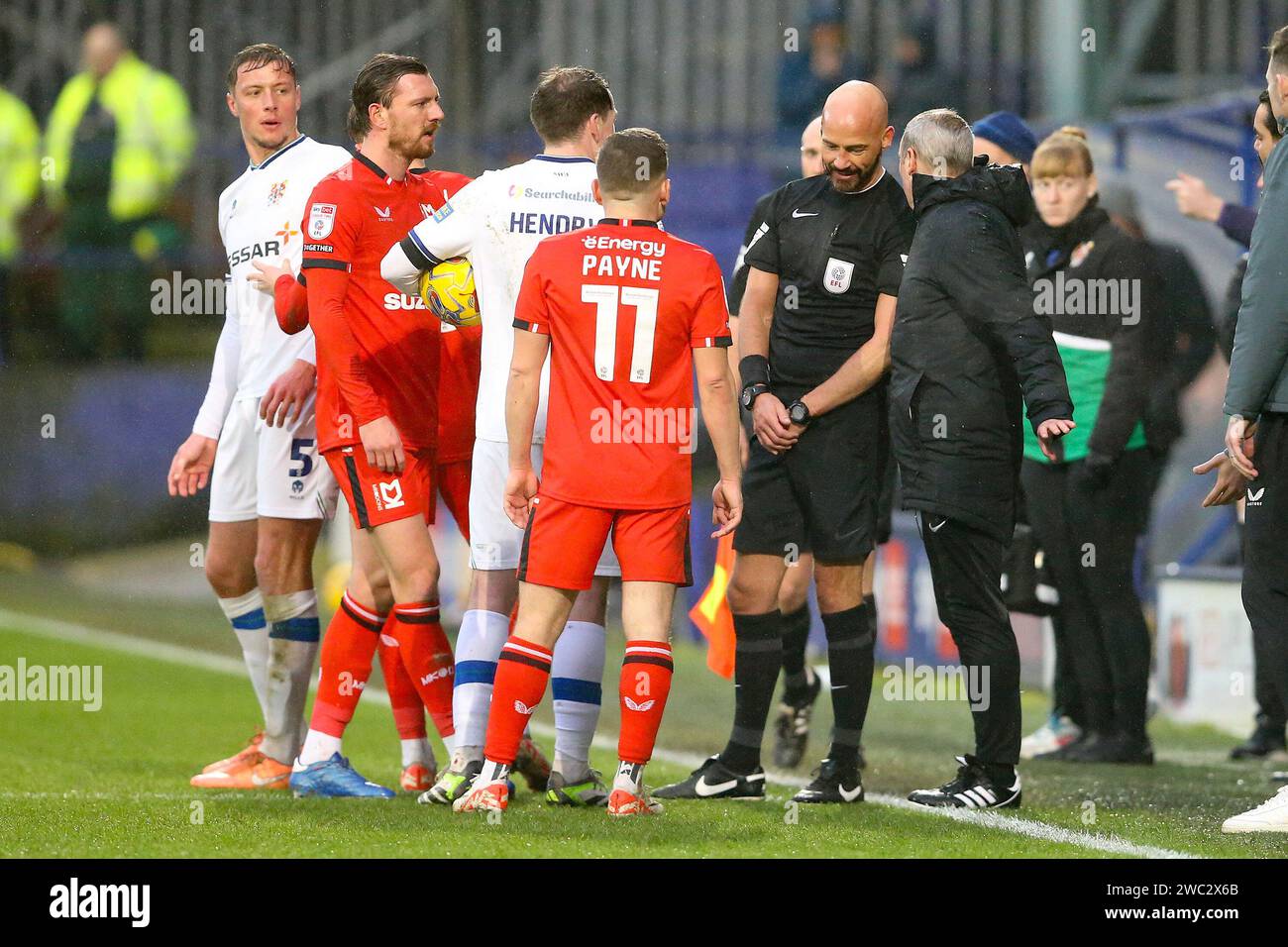 Birkenhead, UK. 13th Jan, 2024. Referee Darren Drysdale consults his Fourth official Alex Gray. EFL Skybet Football league two match, Tranmere Rovers v MK Dons at Prenton Park, Birkenhead, Wirral on Saturday 13th January 2024. this image may only be used for Editorial purposes. Editorial use only, .pic by Chris Stading/ Credit: Andrew Orchard sports photography/Alamy Live News Stock Photo