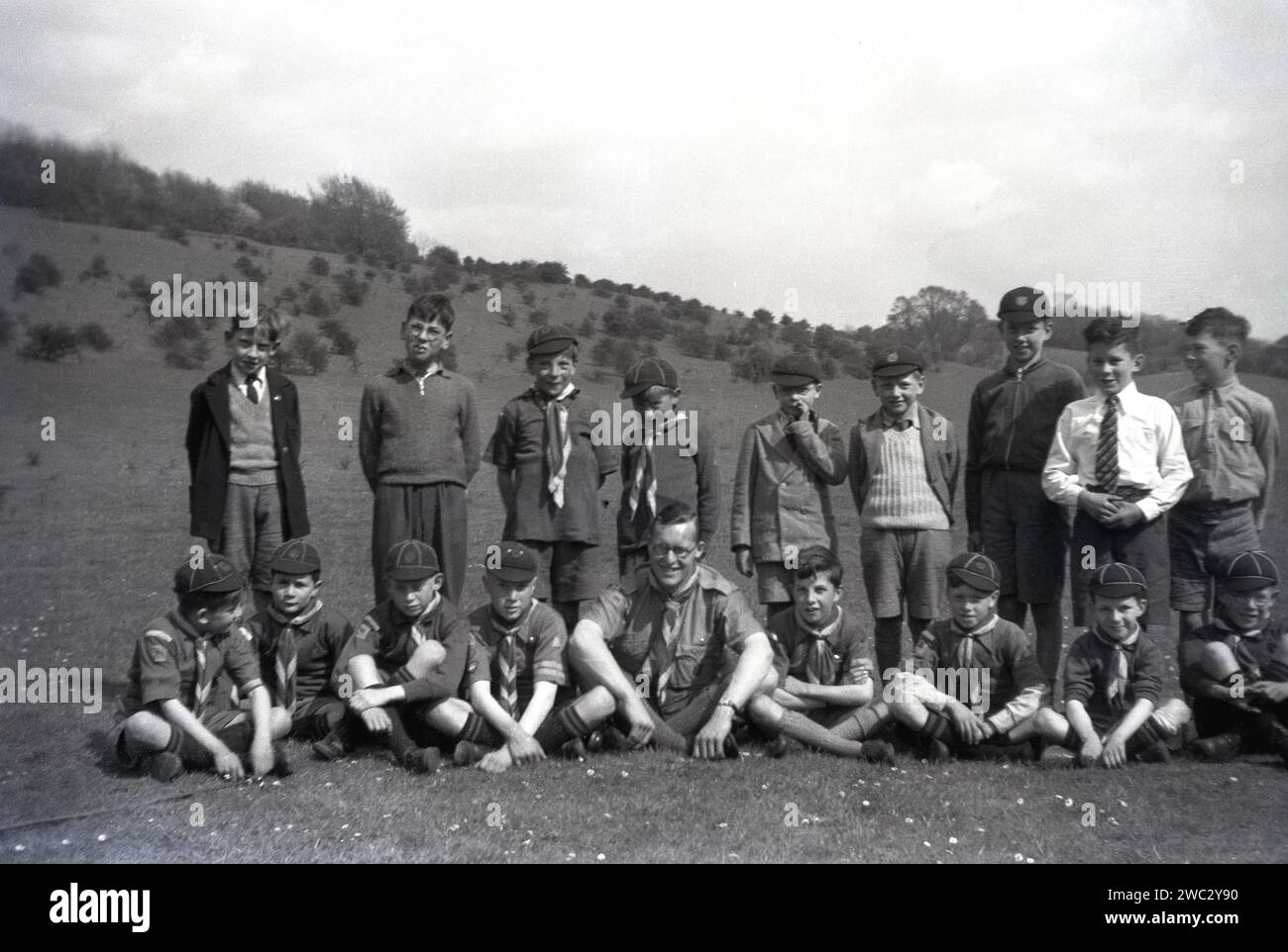 1941, historical, summertime and a picture of the boys scouts of 17th Coulsdon Pack group with their scout leader at Devil's Den, Dorking, Surrey, England, UK. In 1907, Brownsea Island, near Poole, was where the founder of the Scout movement, British Army Officier, Robert Baden-Powell first set up his trial camp for boys and the following year published his famous book, 'Scouting for Boys'. Two years later, with his sister, Agnes, Baden-Powell founded the Girl Guides. Stock Photo