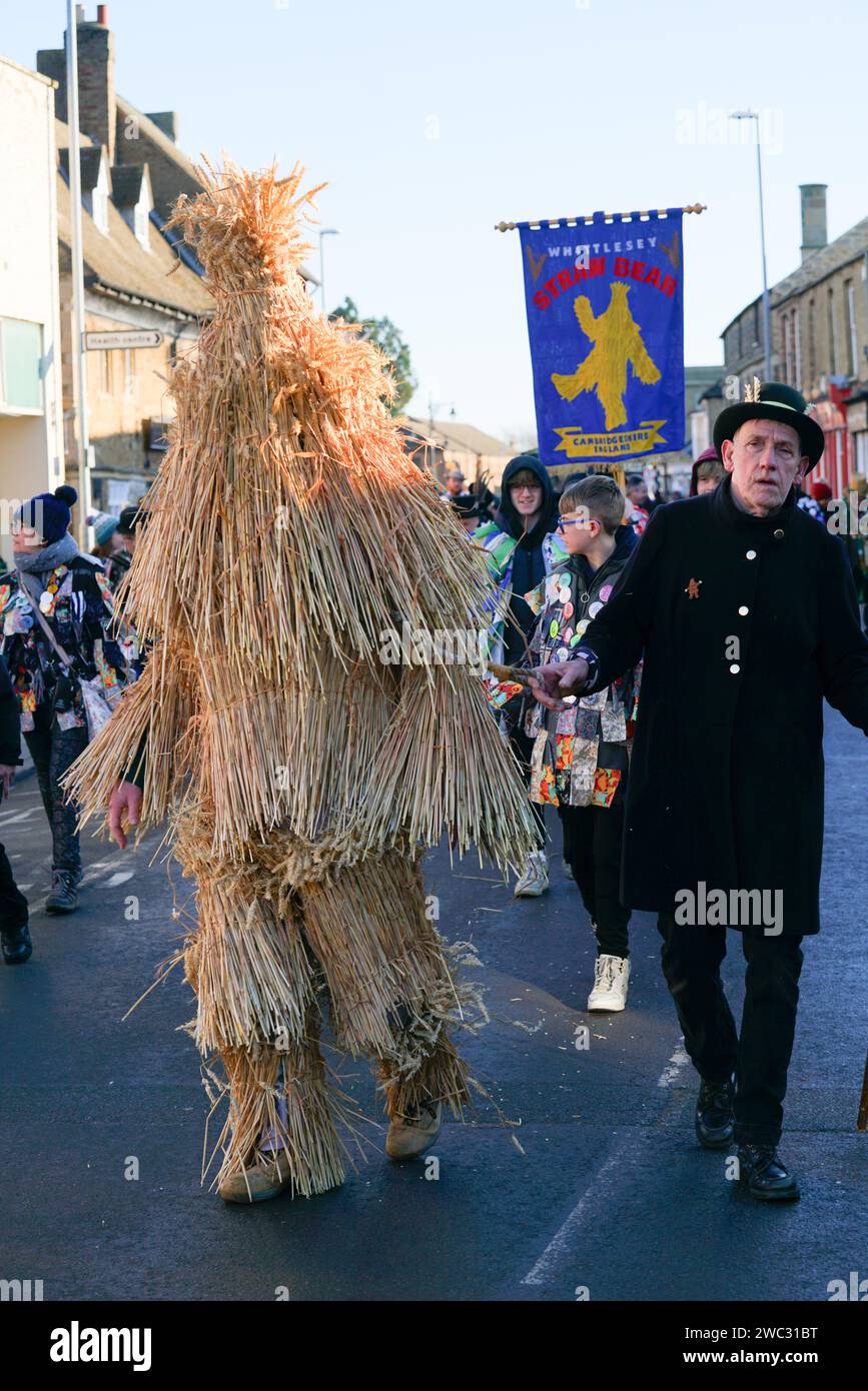 Whittlesey, UK. 13th January 2024. The Whittlesey Straw Bear festival passing through the market town. The event is a tradition that has a 'Straw Bear' (a person dressed in straw) and morris dancers. The traditional event used to took place on the day local farm workers returned to work, also known as Plough Monday .. Andrew Steven Graham/Alamy Live News Stock Photo