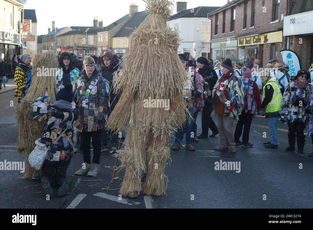 Whittlesey, UK. 13th January 2024. The Whittlesey Straw Bear festival passing through the market town. The event is a tradition that has a 'Straw Bear' (a person dressed in straw) and morris dancers. The traditional event used to took place on the day local farm workers returned to work, also known as Plough Monday. Andrew Steven Graham/Alamy Live News Stock Photo