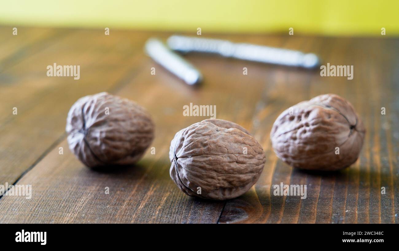 Three walnuts on wooden table Stock Photo
