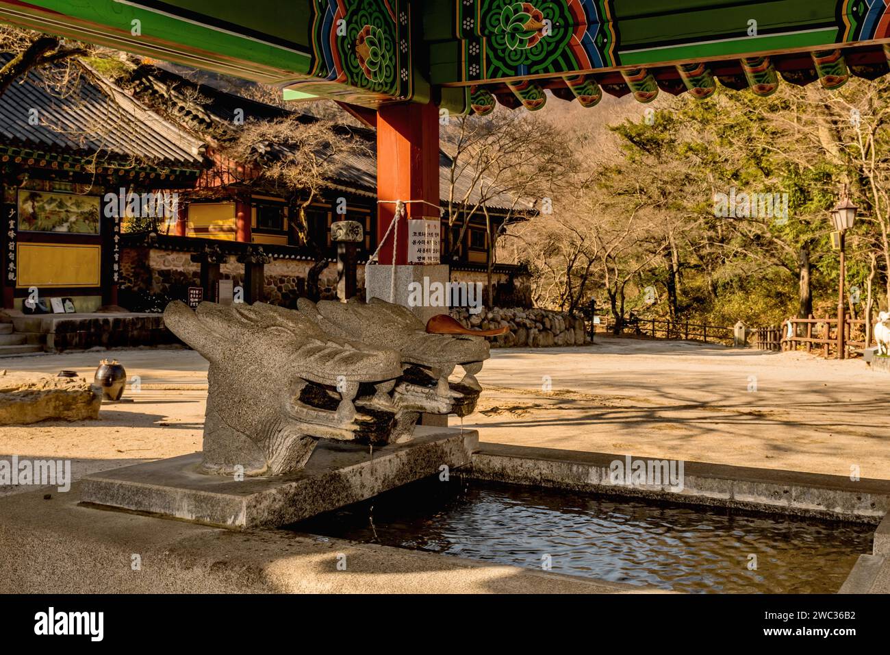 Covered water cistern with dragon head fountains at Buddhist temple Stock Photo