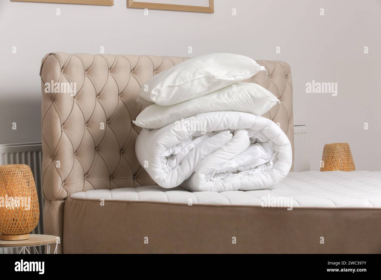 Soft folded duvet and pillows on bed Stock Photo