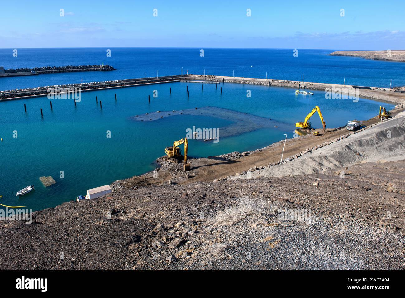 View of two excavators dredging harbour basin new marina harbour for pleasure boats yachts yachts extension of the marina of holiday resort Morro Stock Photo