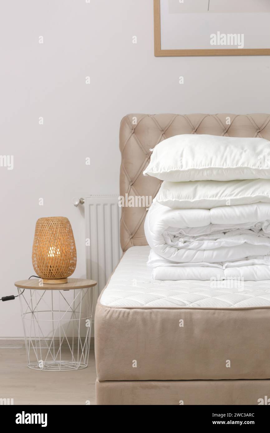 Soft folded duvet and pillows on bed Stock Photo