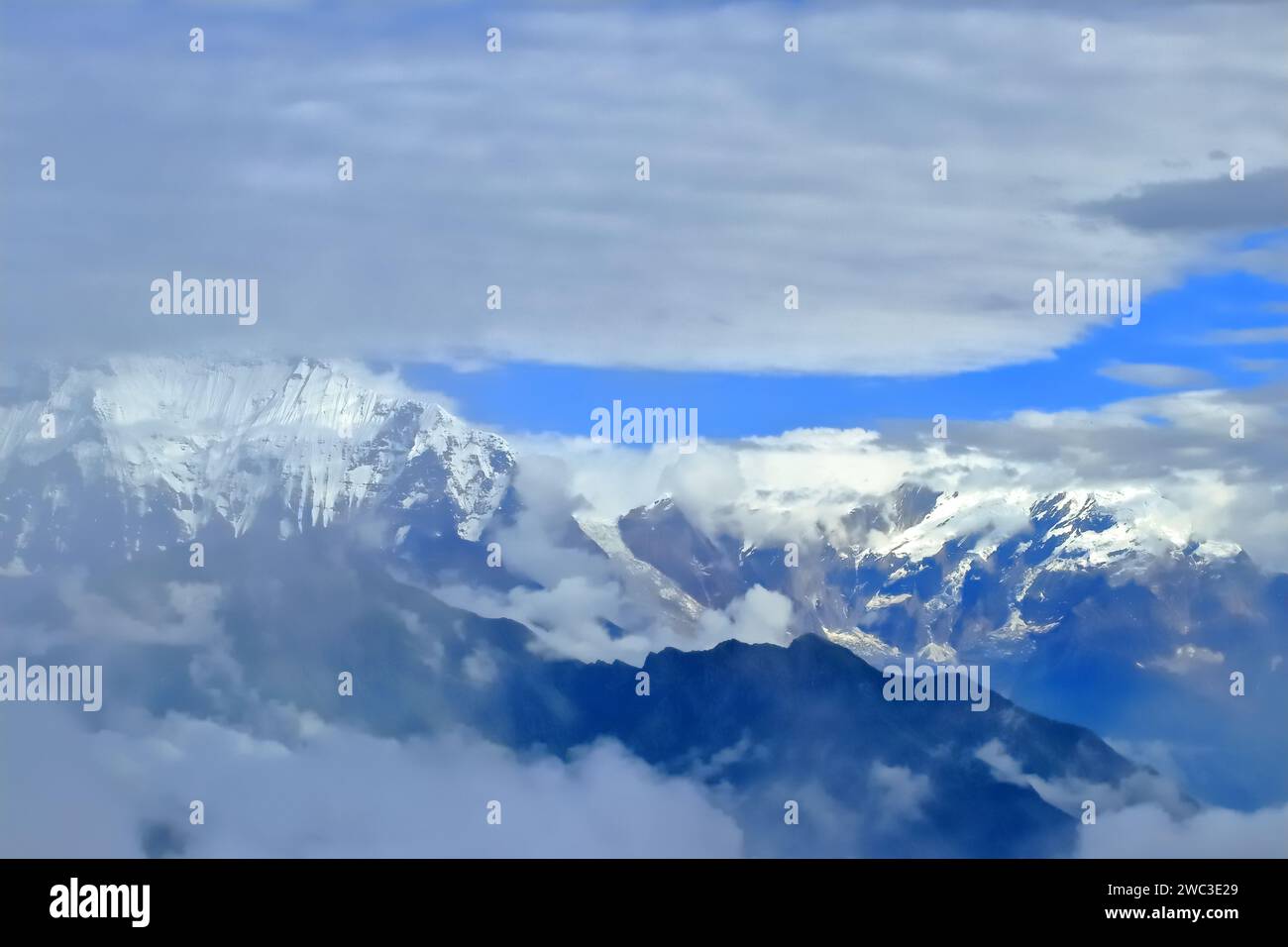 Majestic Veil: Annapurnas' Cloud-Kissed Giants Stock Photo