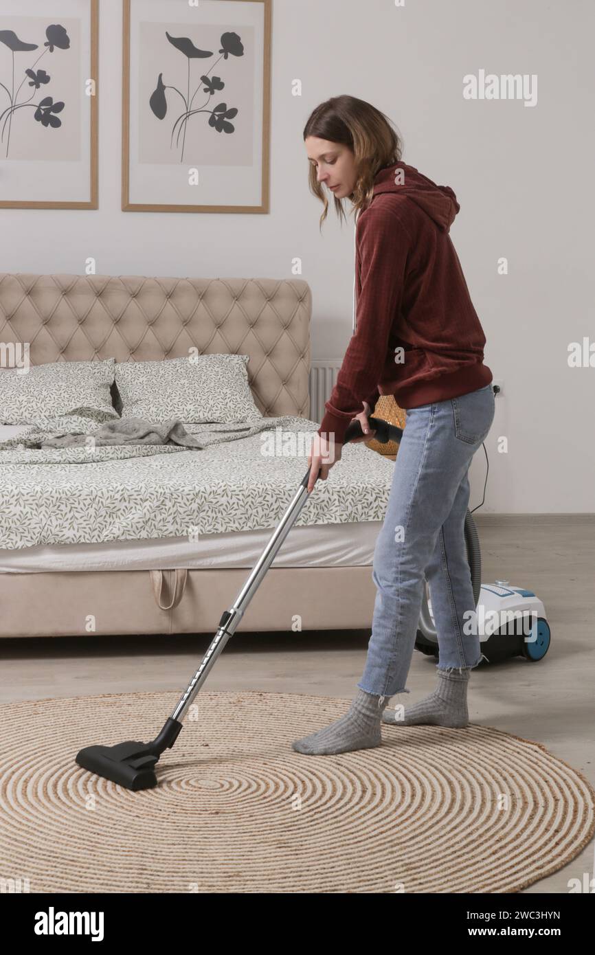 Housewife vacuuming the room, domestic life, apartment cleaning concept Stock Photo