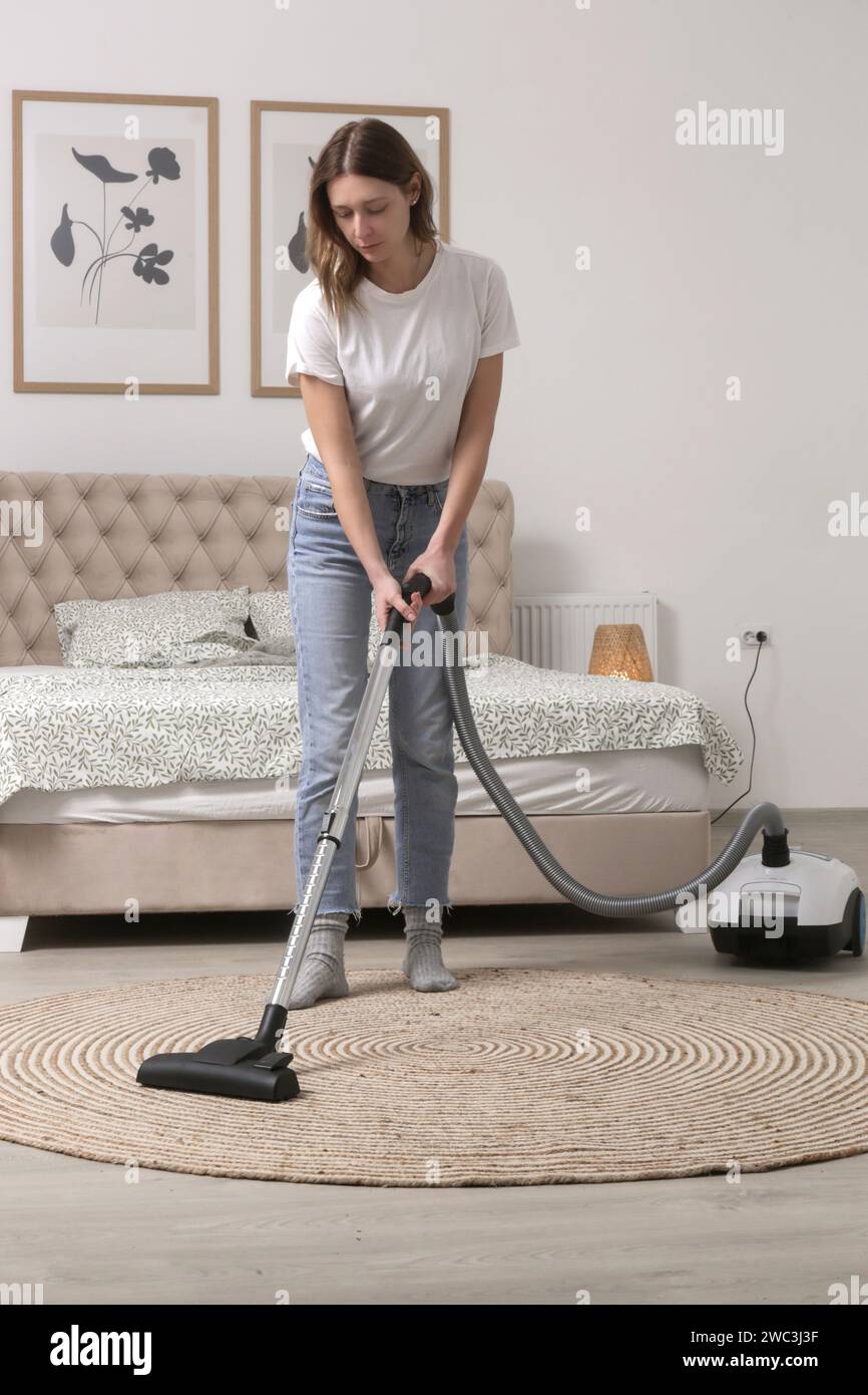 Housewife vacuuming the room, domestic life, apartment cleaning concept Stock Photo