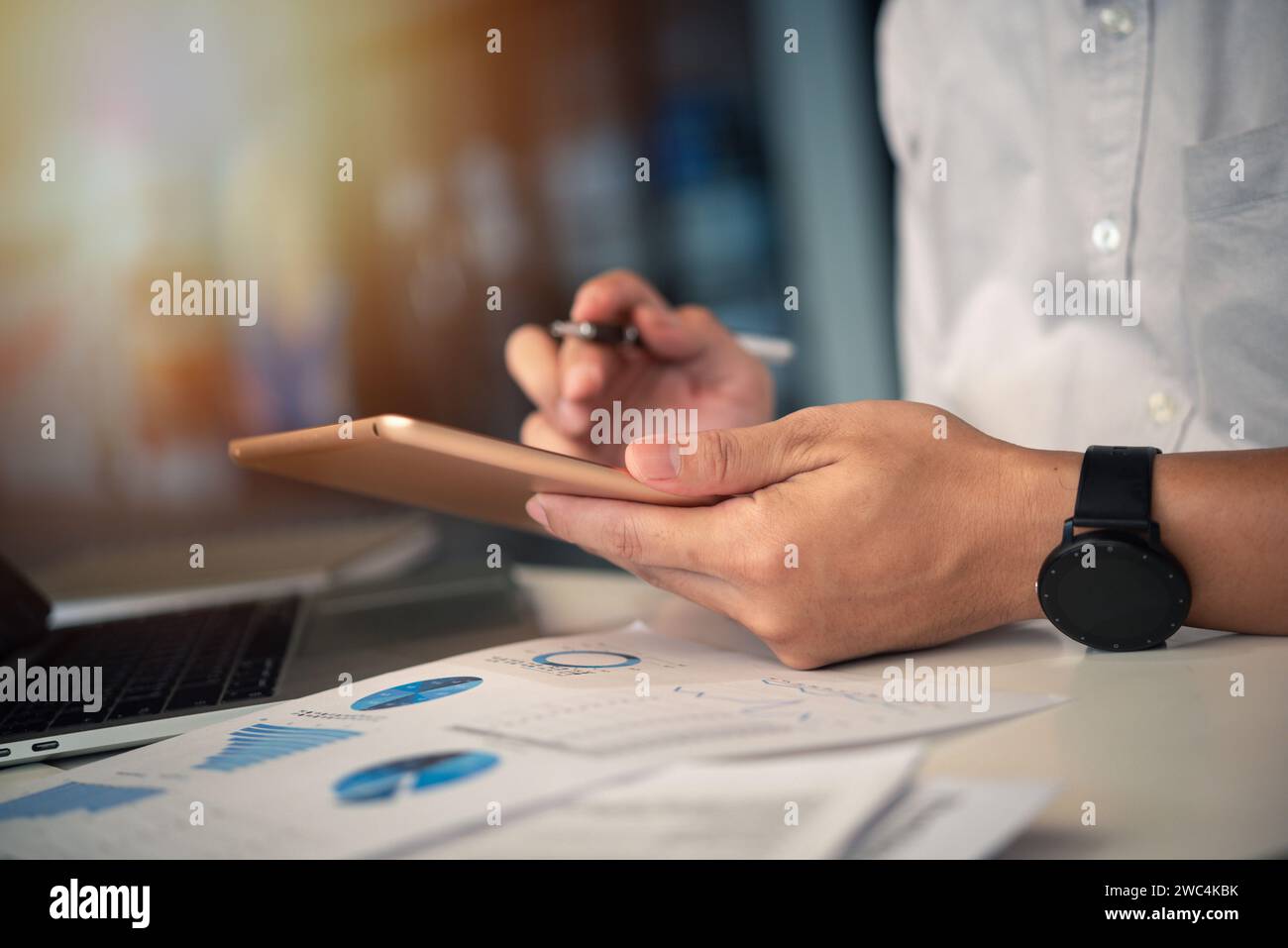 Businessman working with tablet presentation analyzing data planning documents graphs and chart on desk Stock Photo
