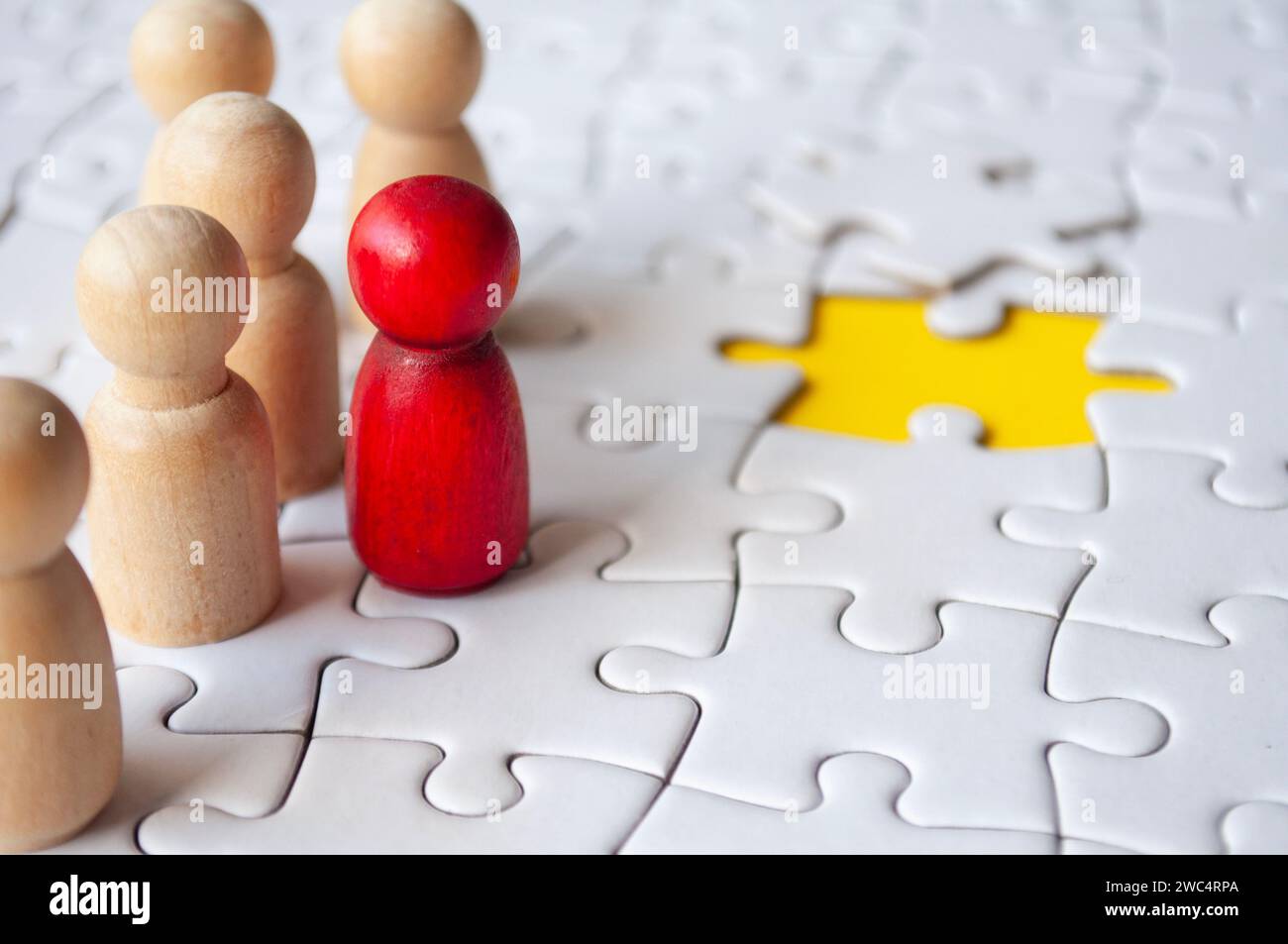 Wooden dolls on jigsaw with missing jigsaw puzzle. Hiring and