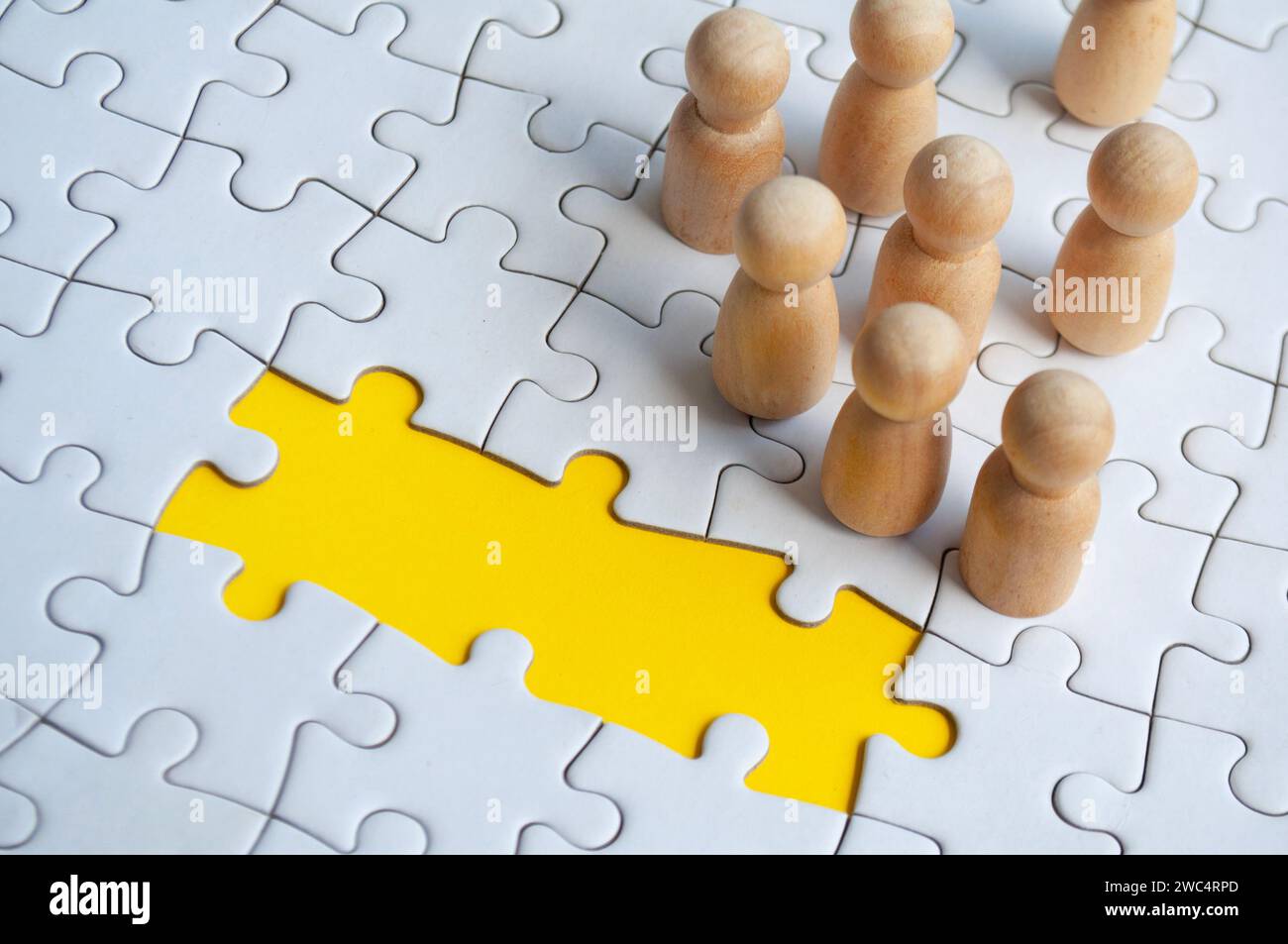 Missing jigsaw puzzle with wooden dolls. Representing hiring and copy space Stock Photo Alamy