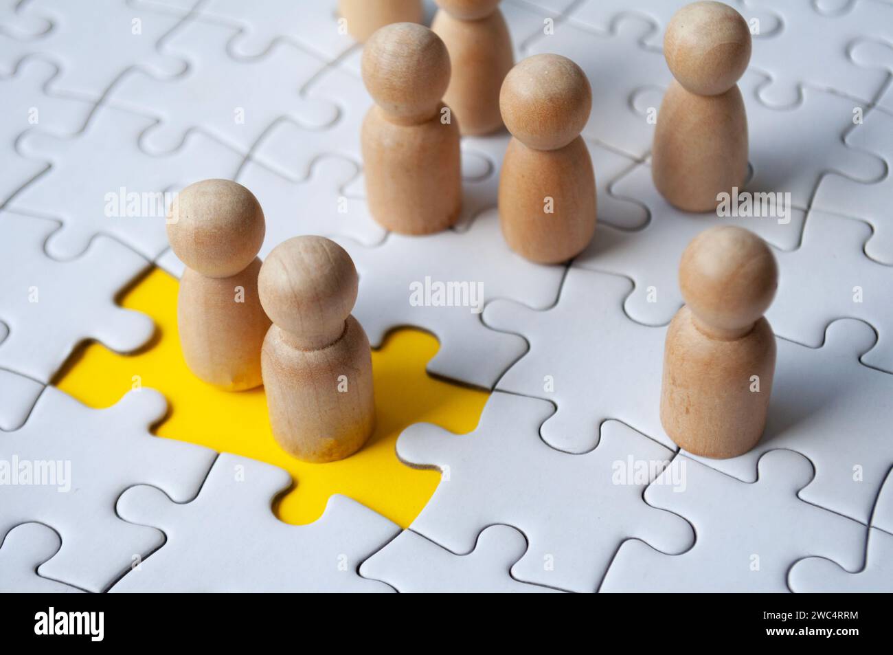 Two wooden dolls filled the missing jigsaw puzzle. Hiring and employment concept Stock Photo