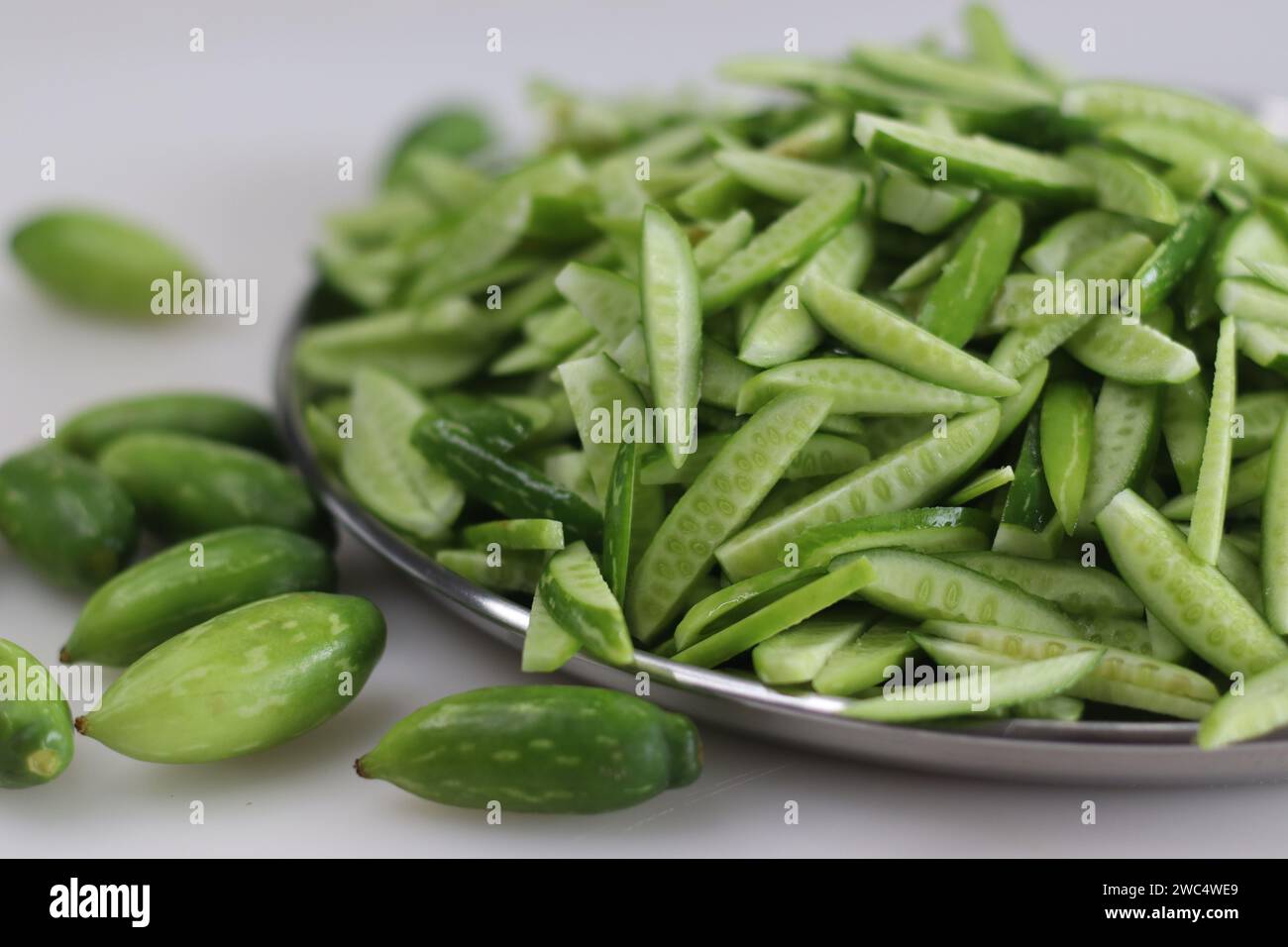 Heap of Ivy gourd or Kovaka vegetables, meticulously sliced lengthwise. Useful for food blogs, menus, and wellness content for promoting healthy lifes Stock Photo