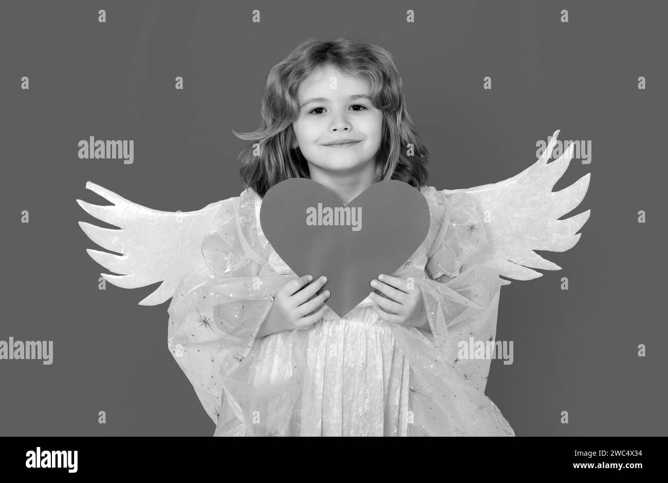 Angel child with heart. Cute angel child, studio portrait. Angel kid