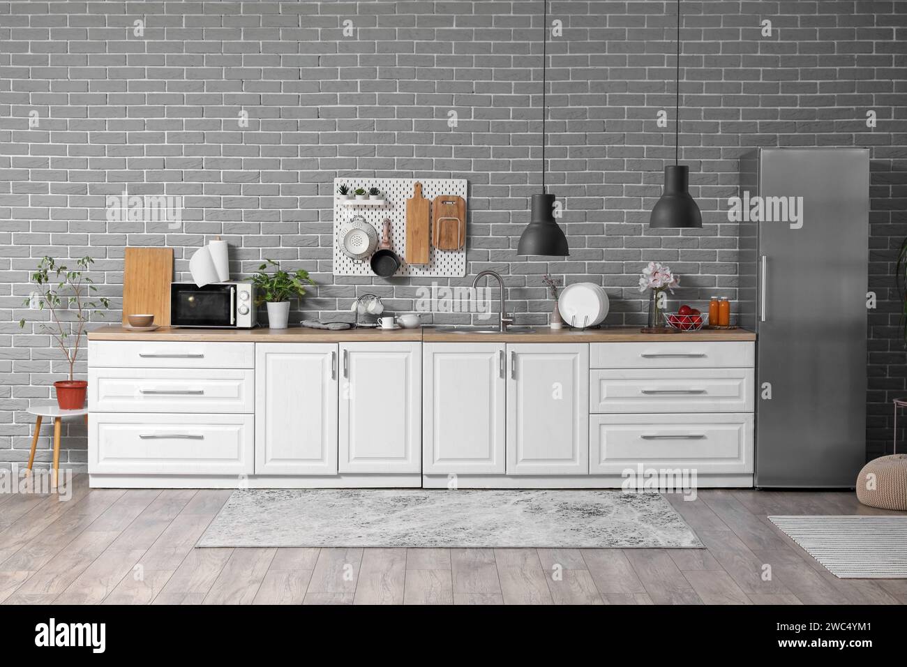 Interior of modern kitchen with white counters and pegboard hanging on ...