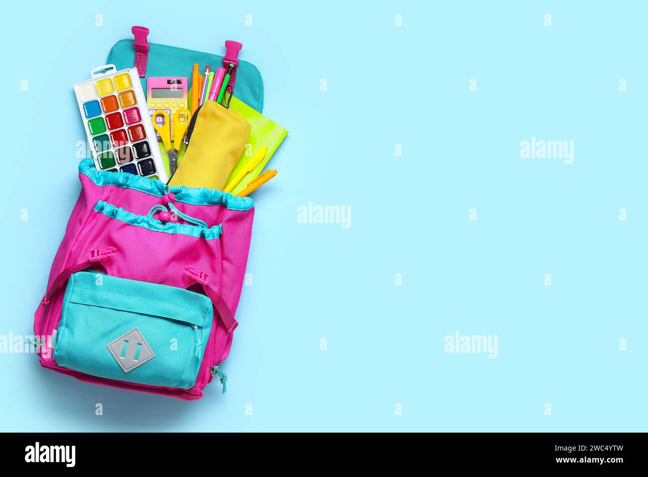 Stylish school backpack with different stationery on blue background Stock Photo