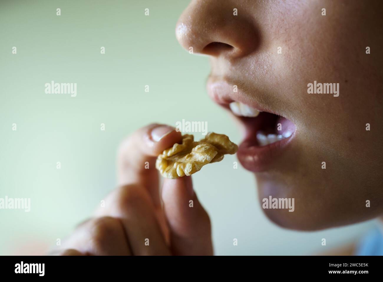 Unrecognizable girl about to eat delicious walnut at home Stock Photo