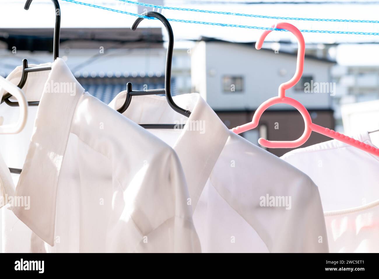 Drying clothes in the sun using a laundry rope that keeps clothes separated in windy conditions Stock Photo