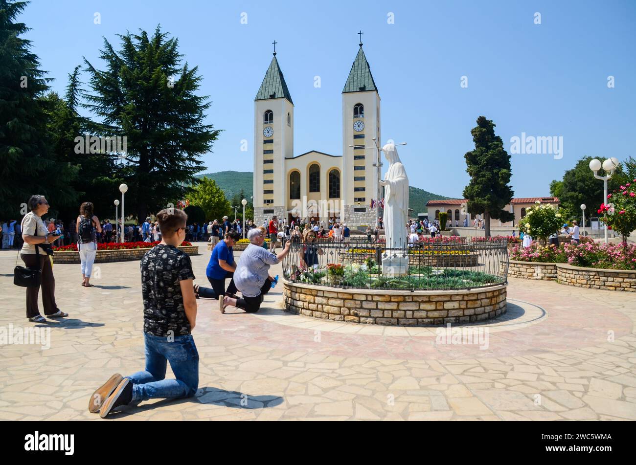 Međugorje, Bosnia and Herzegovina. Catholic pilgrims praying in Medjugorje. People attending a holy mass. Church and statue of Virgin Mary Stock Photo