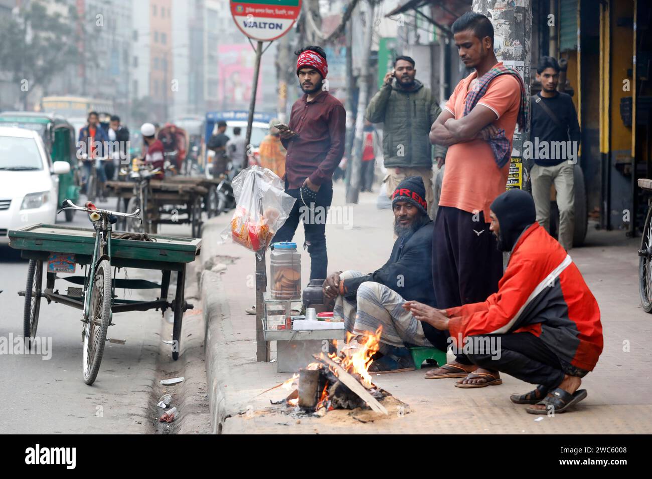 Dhaka, Bangladesh - January 14, 2024: The severe winters across the country are the most difficult for the destitute people. They have lit a fire to g Stock Photo
