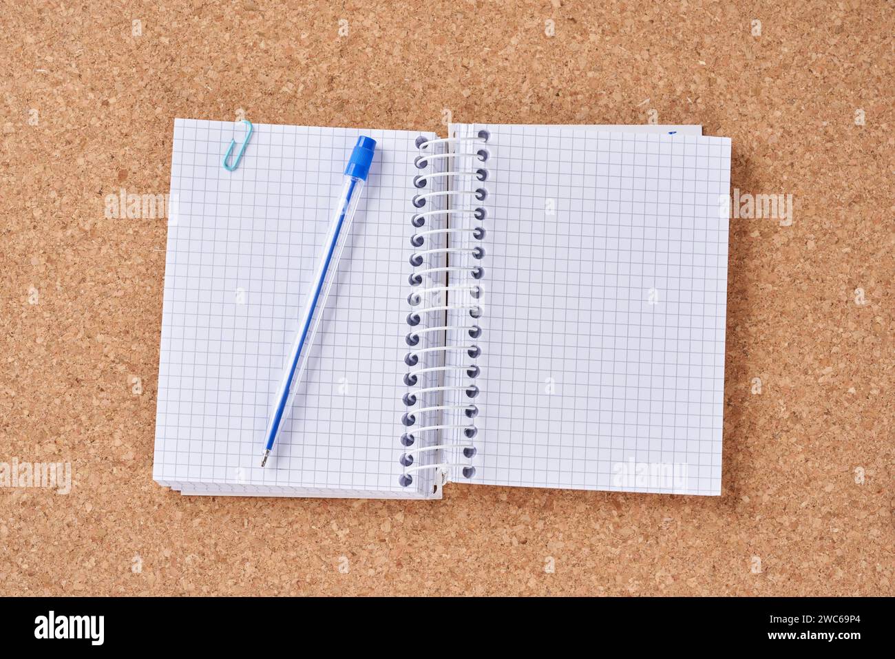 Notepad with ballpoint pen on a cork board. Stock Photo
