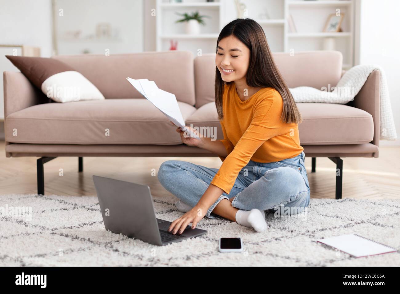 Chinese lady freelancer working from home, using laptop Stock Photo