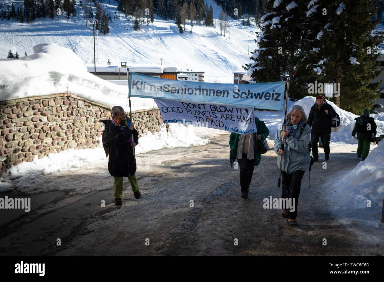 Davos, Switzerland. 14th Jan, 2024. Davos, CH 14 January, 2024. Protesters carry a banner hiking to Davos to protest the 54th World Economic Forum. Hundreds of protesters gathered to voice concerns about this year's WEF agenda. The Forum engages society's political, business, and cultural leaders to shape global, regional, and industry agendas, which can impact everyone around the world. Credit: Andy Barton/Alamy Live News Stock Photo