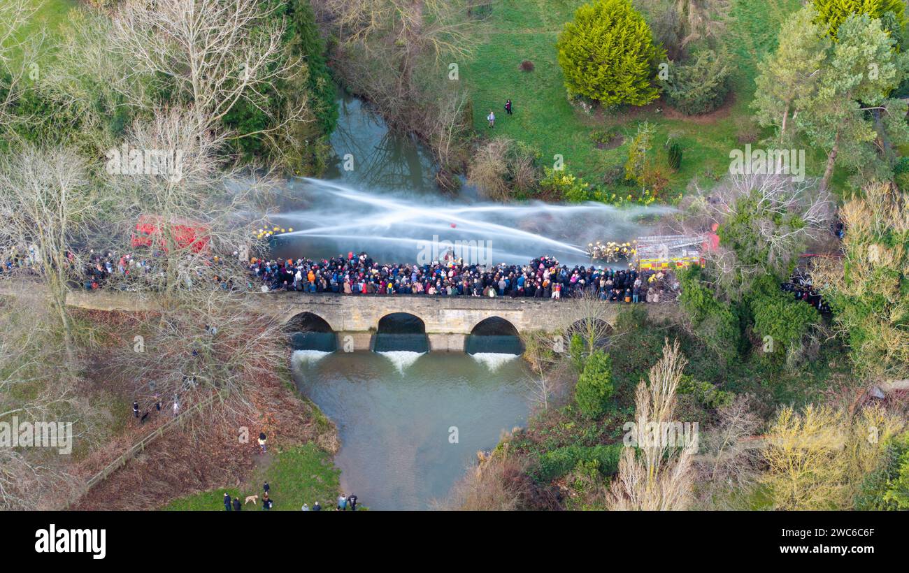 Geddington's traditional Boxing Day 'squirt' by the Northamptonshire ford that saw two teams of firefighters battle for supremacy with hoses next t Stock Photo