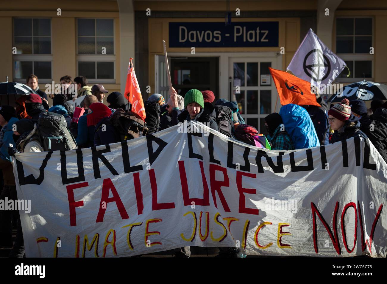 Davos, Switzerland. 14th Jan, 2024. Davos, CH 14 January, 2024. Protesters with banners hike past Davos Platz train station to protest the 54th World Economic Forum. Hundreds of protesters gathered to voice concerns about this year's WEF agenda. The Forum engages society's political, business, and cultural leaders to shape global, regional, and industry agendas, which can impact everyone around the world. Credit: Andy Barton/Alamy Live News Stock Photo