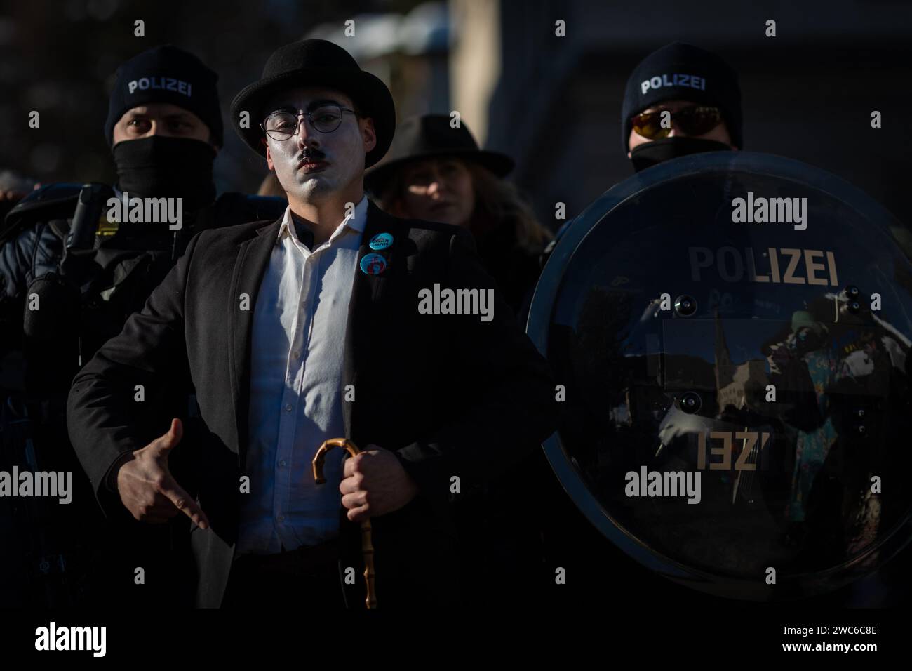 Davos, Switzerland. 14th Jan, 2024. Davos, CH 14 January, 2024. A protester is stopped by a police cordon during the 54th World Economic Forum. Hundreds of protesters gathered to voice concerns about this year's WEF agenda. The Forum engages society's political, business, and cultural leaders to shape global, regional, and industry agendas, which can impact everyone around the world. Credit: Andy Barton/Alamy Live News Stock Photo