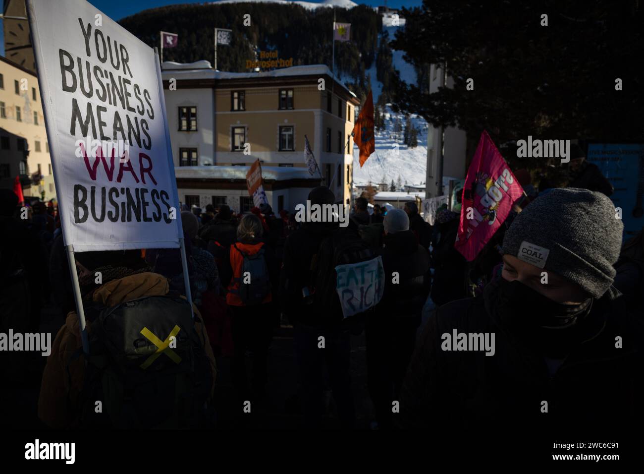 Davos, Switzerland. 14th Jan, 2024. Davos, CH 14 January, 2024. A banner is held during protest speeches during the 54th World Economic Forum. Hundreds of protesters gathered to voice concerns about this year's WEF agenda. The Forum engages society's political, business, and cultural leaders to shape global, regional, and industry agendas, which can impact everyone around the world. Credit: Andy Barton/Alamy Live News Stock Photo