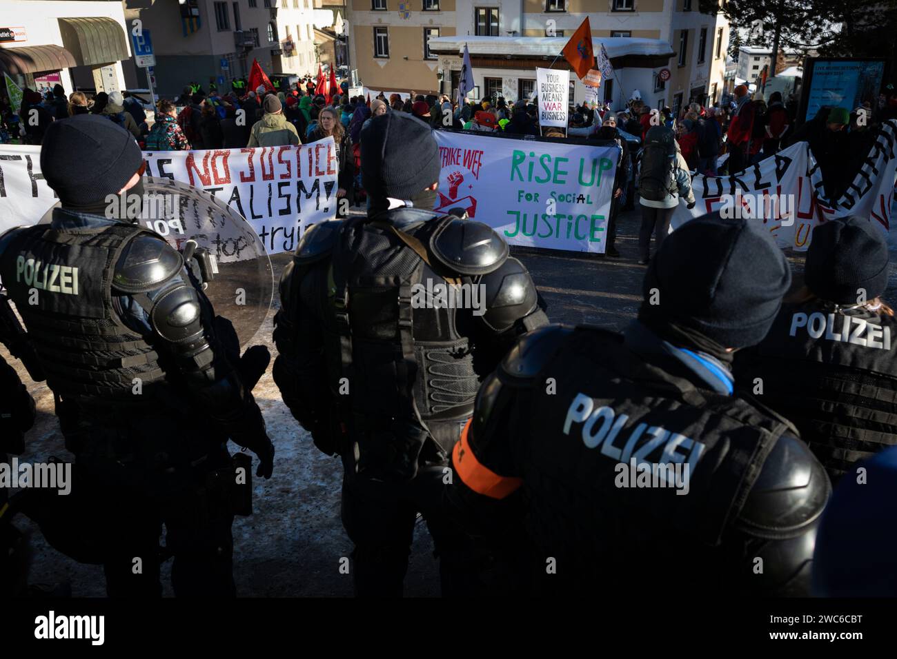 Davos, Switzerland. 14th Jan, 2024. Davos, CH 14 January, 2024. Riot police monitor a rally against the 54th World Economic Forum. Hundreds of protesters gathered to voice concerns about this year's WEF agenda. The Forum engages society's political, business, and cultural leaders to shape global, regional, and industry agendas, which can impact everyone around the world. Credit: Andy Barton/Alamy Live News Stock Photo