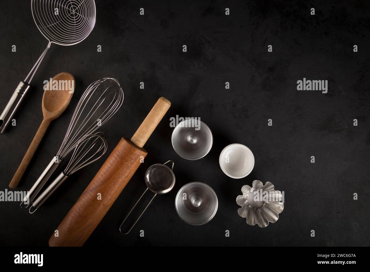 kitchen utensils on black background, seen from above. Stock Photo