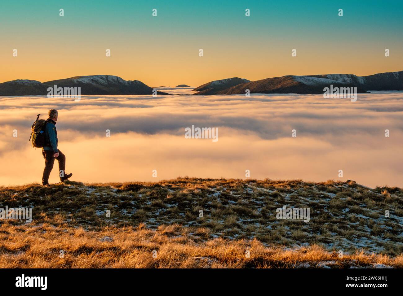 A hill walker on the High Street range in the Lake District National Park, with a cloud inversion / temperature inversion in the distance Stock Photo