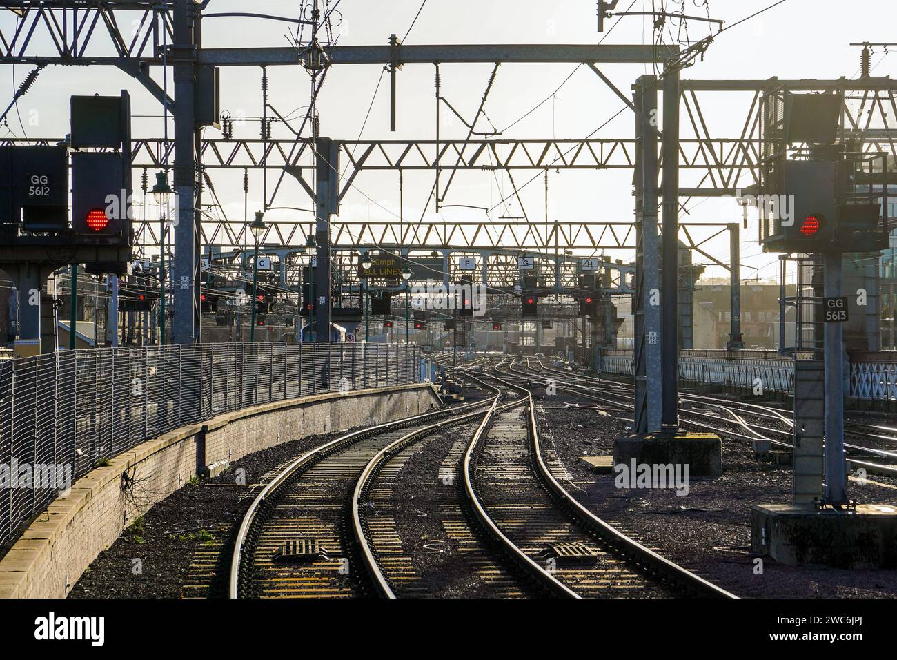 Railway tracks and overhead gantry signals at red on the appraoch to ...