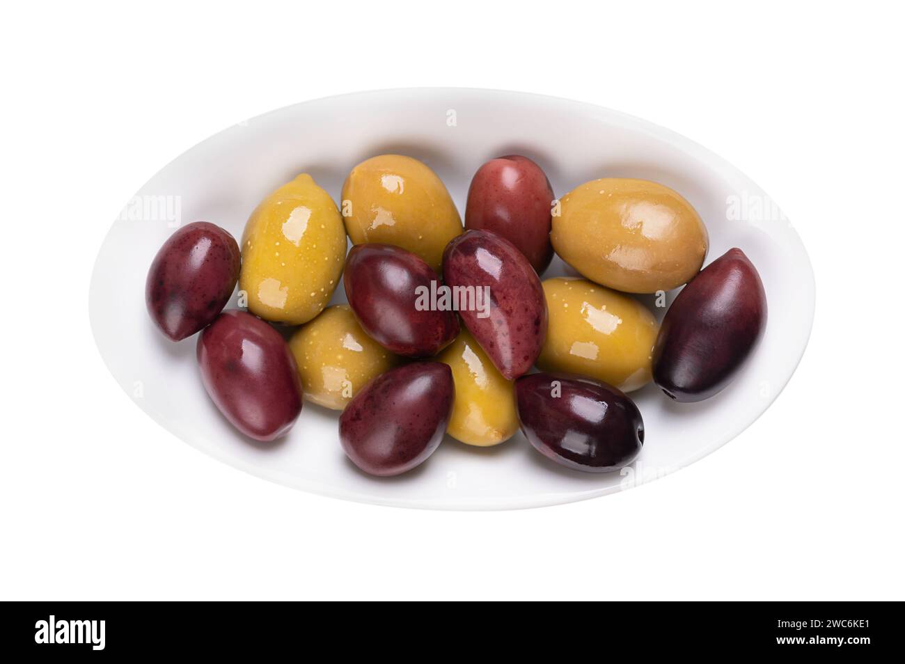 Kalamata and green olives with pit, pickled whole, large Greek table olives, in a white oval bowl. Stock Photo