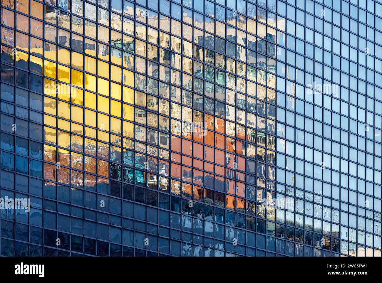 The highly reflective curtain wall of Four World Trade Center mirrors its surroundings from every angle, above the triple-height clear glass base. Stock Photo