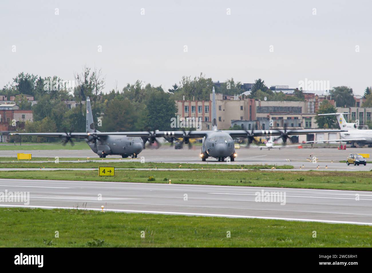 A pair of US Air Force Lockheed C-130 Hercules military transport airplanes taxiing for takeoff from Lviv Stock Photo