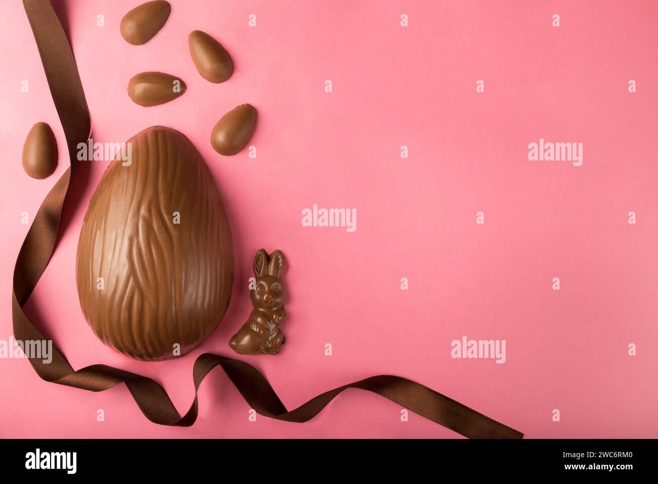 Easter. Composition with chocolate Easter eggs on pink background, space for text. Stock Photo
