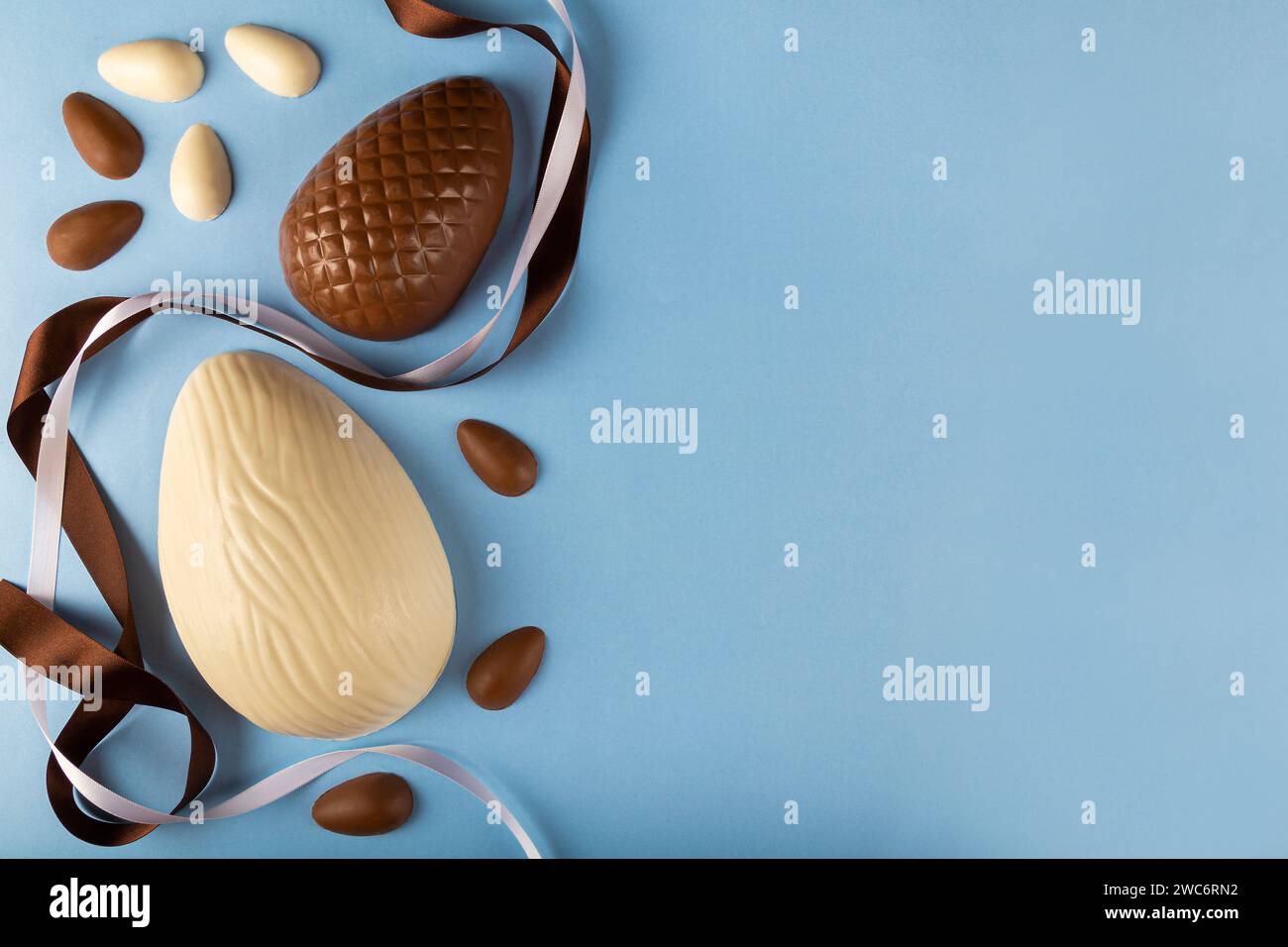 Easter. Composition with chocolate easter eggs on blue background, space for text. Stock Photo
