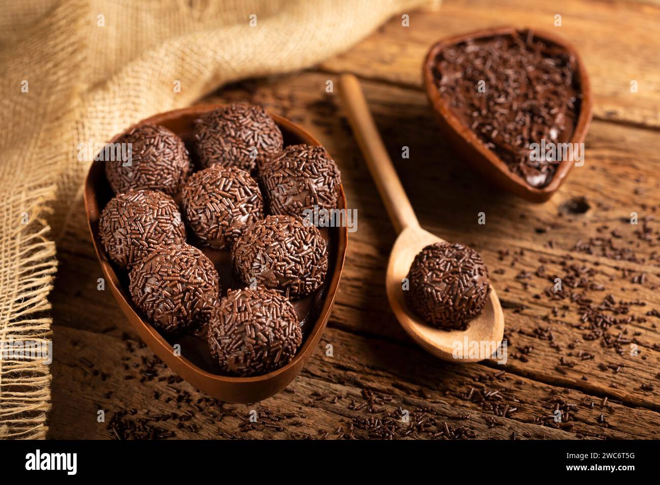 Chocolate Easter eggs stuffed with brigadiers on rustic wooden background. Stock Photo