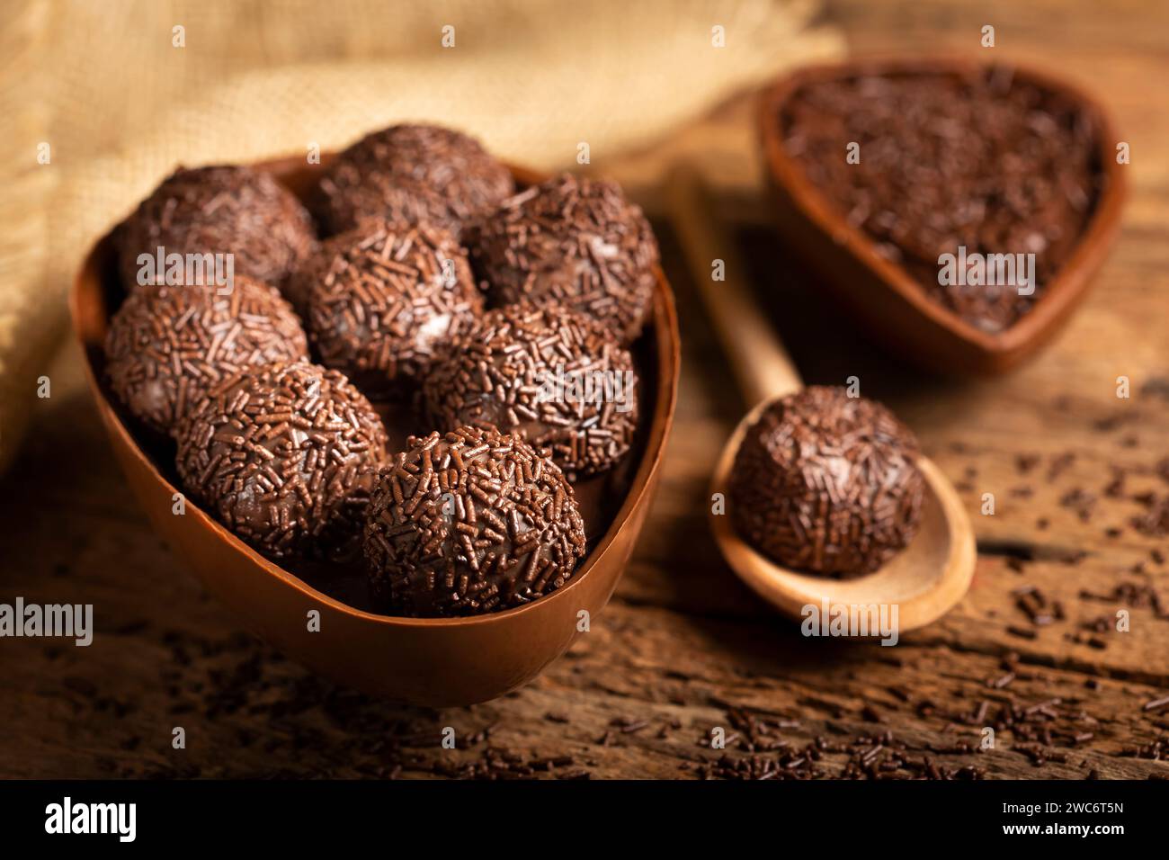 Chocolate Easter eggs stuffed with brigadiers on rustic wooden background. Stock Photo