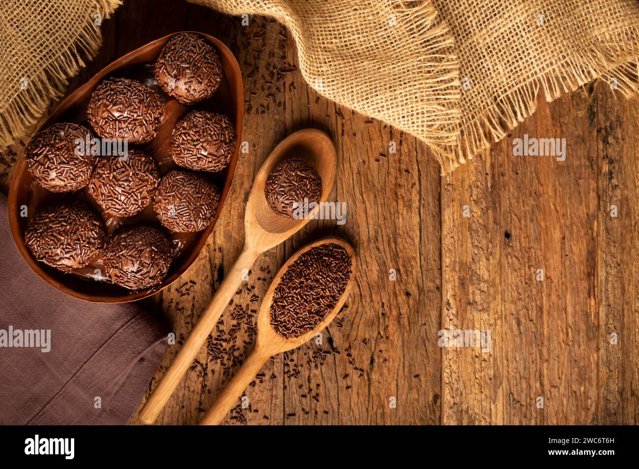 Chocolate Easter eggs stuffed with brigadiers on rustic wooden background. Stock Photo