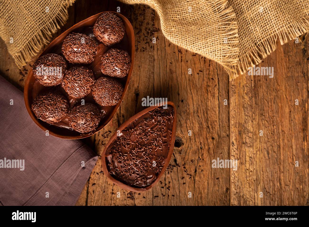 Chocolate Easter eggs stuffed with brigadiers on rustic wooden background. Stock Photo