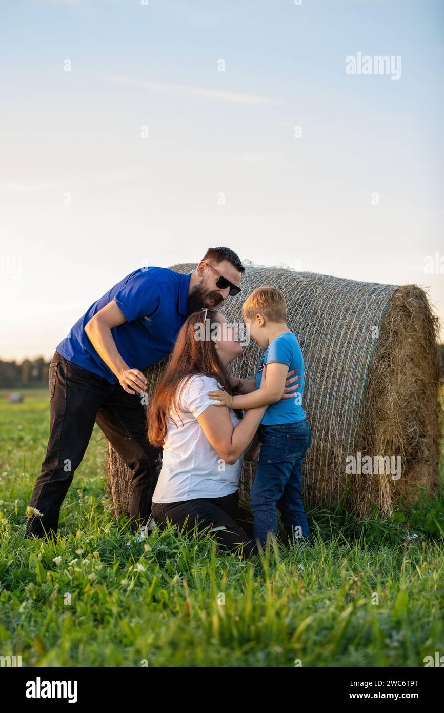 Fun family games with their son in the summer meadow on a warm beautiful day. Stock Photo