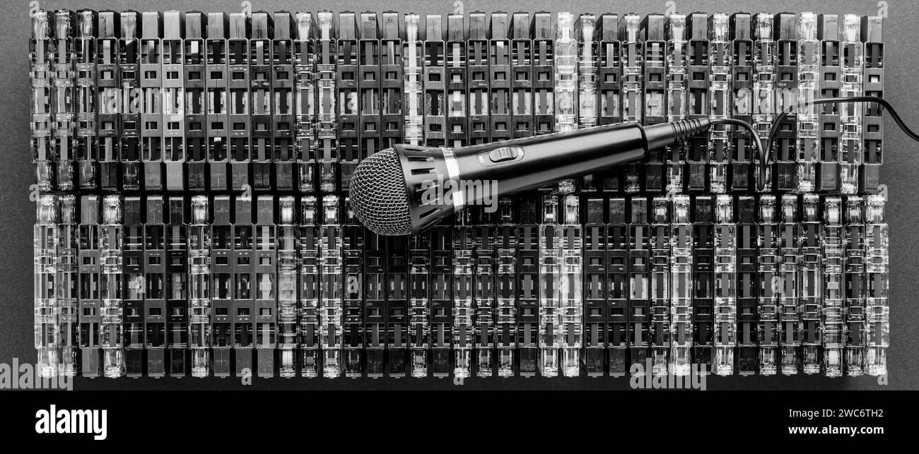 Audio cassettes are lined up in two rows with the tapes facing up and the microphone on them. A panoramic, black and white photo suitable for a banner Stock Photo