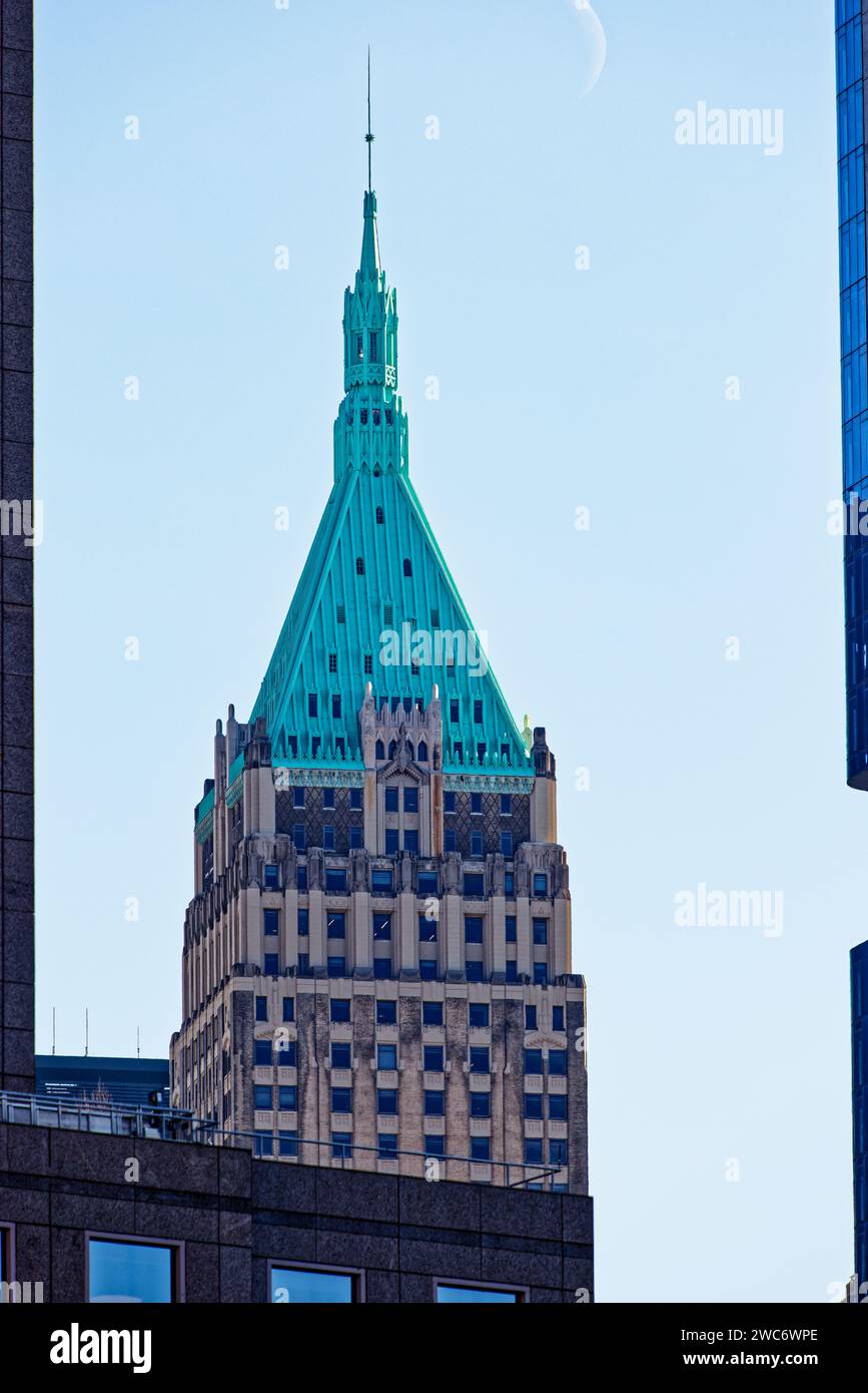 A verdigris pyramid and cupola marks 40 Wall Street, an historic landmark skyscraper, renamed Trump Building, in NYC’s Financial District. Pale cresce Stock Photo