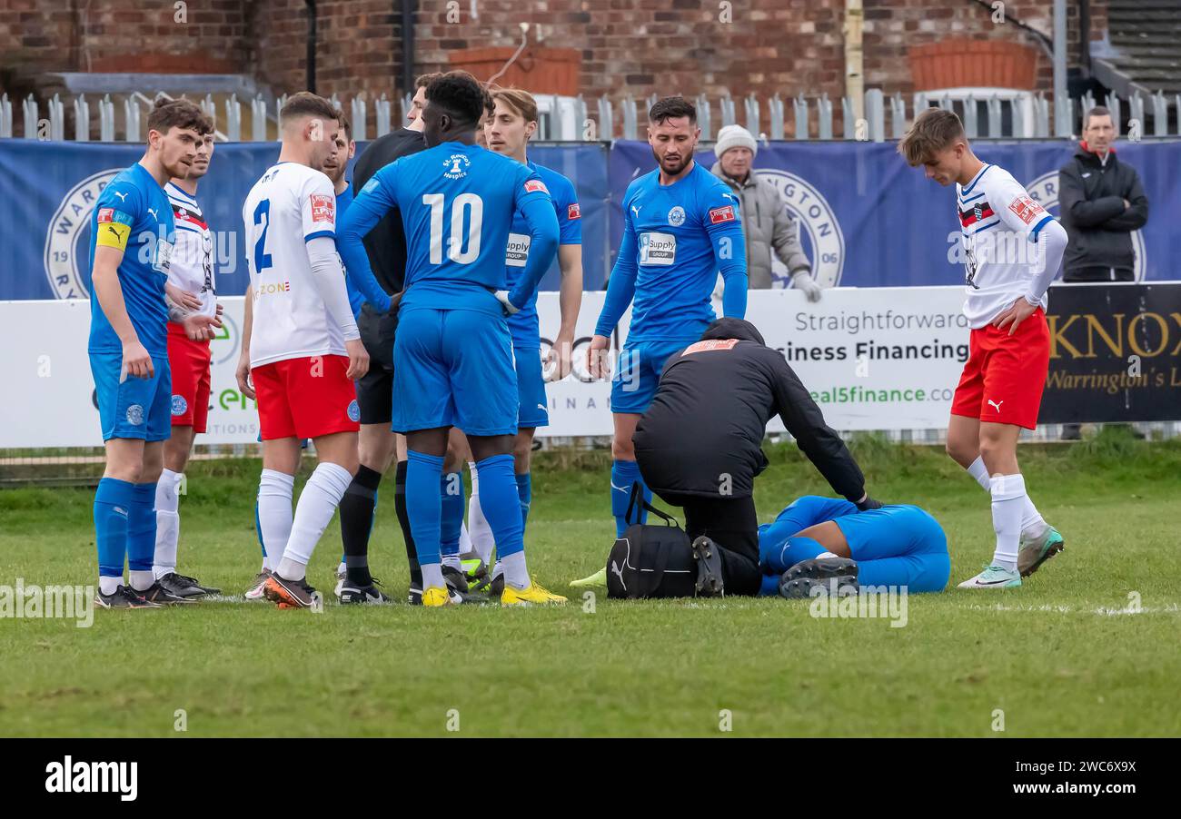 A Warrington Rylands player lies injured on the pitch during a match against Whitby Town at The Hive Stadium, Warrington, Cheshire, England Stock Photo