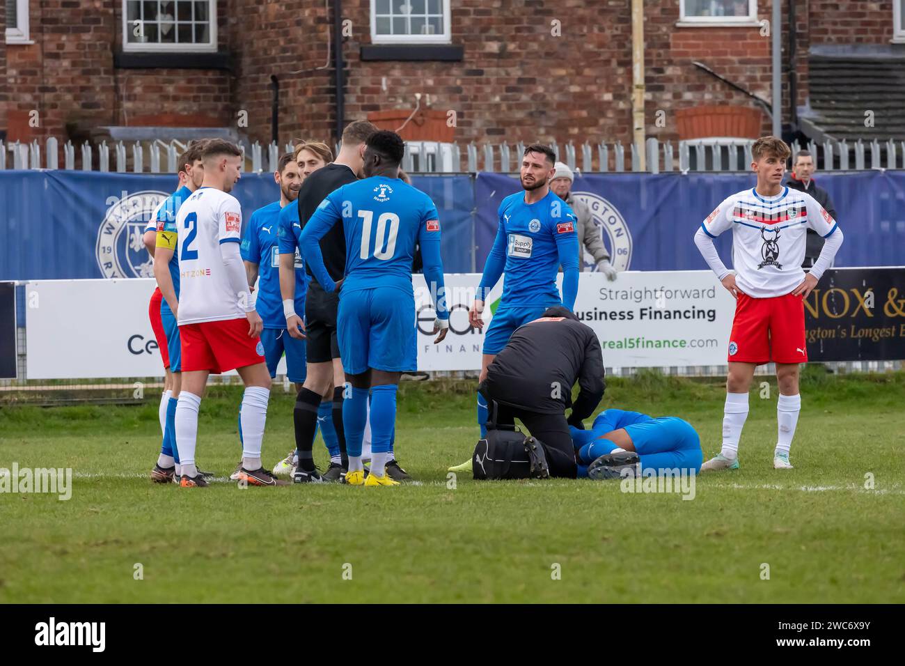 A Warrington Rylands player lies injured on the pitch during a match against Whitby Town at The Hive Stadium, Warrington, Cheshire, England Stock Photo