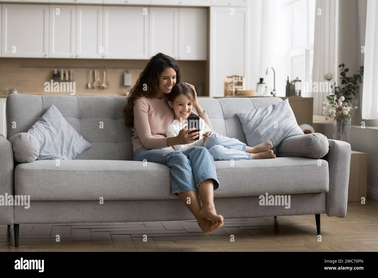 Happy mom and cute little tween kid girl using application Stock Photo ...